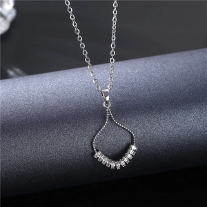 Silver skirt-shaped necklace with micro-pave zircons on a dark fabric background