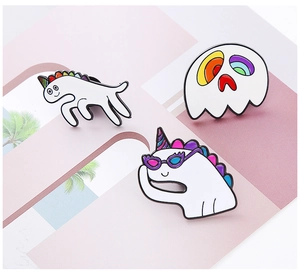 Detailed macro of white unicorn, ghost and pony enamel pins with rainbow accents
