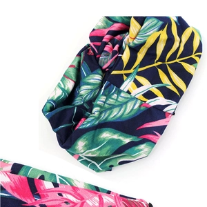 Detail of bohemian criss-cross headband featuring vibrant tropical leaf prints on soft fabric