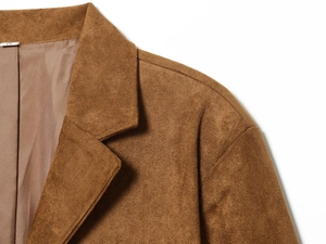 Detail of a brown faux suede blazer collar and shoulder texture with high-quality stitching