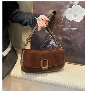 Detail of dark brown suede shoulder bag featuring a vintage square metal buckle accent