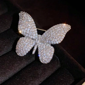 Elegant butterfly brooch with sparkling crystals on dark velvet for formal wear