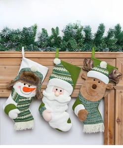 Detailed view of three green Christmas stockings with Santa and snowman on a wooden mantel