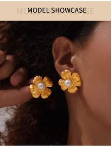 Close-up of vintage flower pearl earrings with gold brushed texture on a model showcase