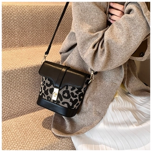 Detail of leopard print bucket bag featuring premium gold-tone lock and leather strap