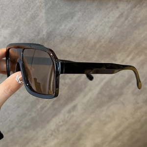 Detail view of vintage square sunglasses with black frame and dark brown lenses