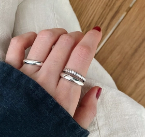 Close-up of three-piece 925 sterling silver minimalist layered twisted ring set on model
