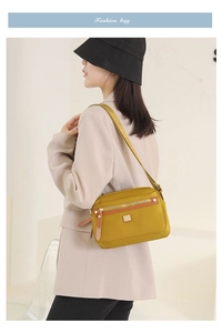 Detail of bright yellow waterproof nylon crossbody bag with wide jacquard shoulder strap