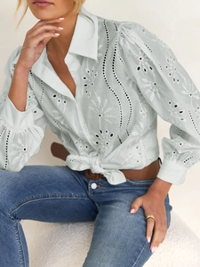 Detailed view of white hollow lace embroidery and elegant puff sleeves on this stylish shirt