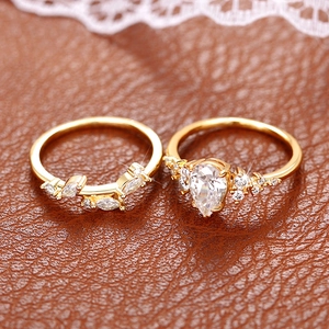 Detailed close-up of leaf-inspired v-shaped ring set with pear-shaped zircon on leather