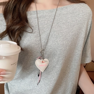 Detailed view of white heart leather pendant on a silver ball chain necklace