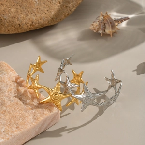 Starfish-shaped stackable bracelets in gold and silver finish on ocean themed background