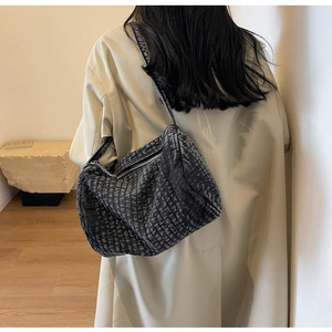 Detail shot of washed denim shoulder bag in black-grey with textured fabric and zip closure
