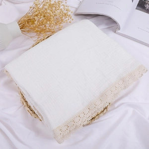 Close-up of white double-layer cotton baby blanket with delicate lace trim detail