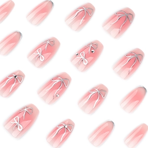 Pink gradient press-on nails with silver bows and rhinestone accents in short ballet style