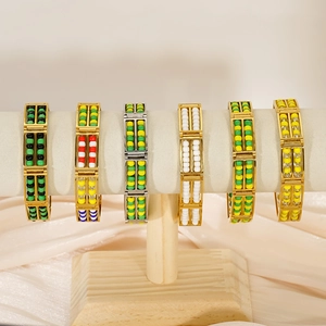 Gold and silver stainless steel bead bracelets in various colors on a silk display stand