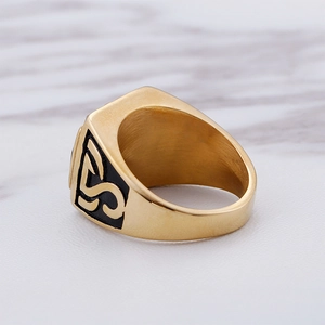 Detail of gold hip hop ring showing brushed interior finish and black enamel side design