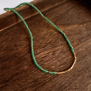 Macro shot of 18K gold plated green aventurine beads on a vintage necklace