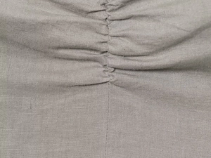 Detailed view of grey linen blend fabric with elegant ruched texture and gathered design