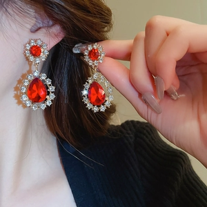 Détail de boucles d'oreilles vintage dorées avec gemmes rouges et strass brillants