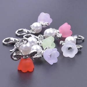 Detail of colorful angel wing favors with pearls and lobster clasps for wedding gifts