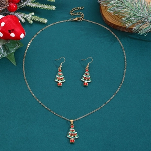 Nahaufnahme des Weihnachtsbaum-Schmucksets mit Emaille-Anhängern auf dunkelgrünem Grund