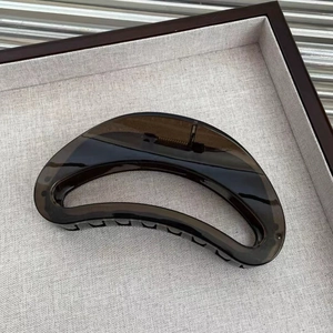 Detailed view of large amber tortoiseshell hair claw clip with strong metal spring