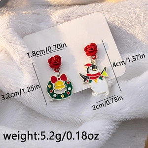 Detailed size view of asymmetric Christmas earrings with wreath and penguin motifs