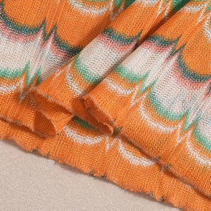 Détail de maille au crochet avec motif ondulé orange, vert, blanc et ourlet ondulé