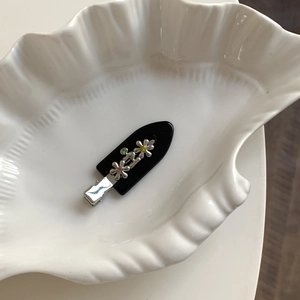 Pince à cheveux fleurie en métal avec strass colorés sur support en acrylique