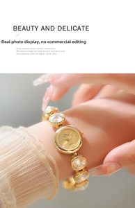 Montre à quartz élégante dorée avec bracelet en strass portée au poignet d'une femme