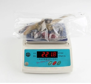 Realistic triceratops toy weight measurement showing 221.8g on a digital scale