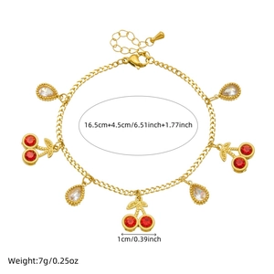 Detailed view of golden cherry charm bracelet with red and clear rhinestones