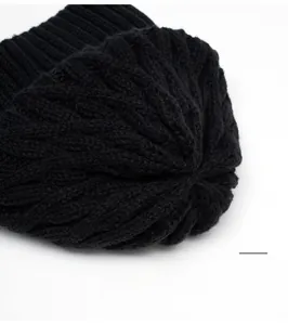 Detailed view of the black knit beanie crown with sturdy stitching and cable pattern