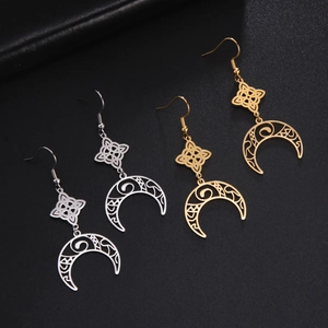 Detail of hollowed witch knot and crescent moon tassel earrings in gold and silver finish