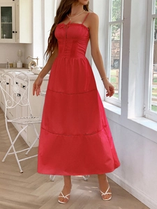 Macro detail of a red maxi dress featuring a layered tiered skirt and cinched waistline
