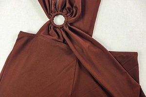 Détail de la combinaison brun rouge avec anneaux métalliques et design à lanières ajourées