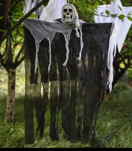 Outdoor Halloween hanging ghost decoration with skull and gauze drapes on tree
