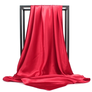 Detail of red satin square scarf showing smooth glossy texture and elegant drape