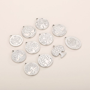 Détail de dix pendentifs arbre de vie en argent aux designs évidés et gaufrés ronds