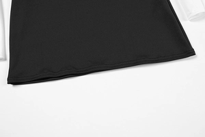 Close-up of contrast stitching and fabric texture on a black and white patchwork dress