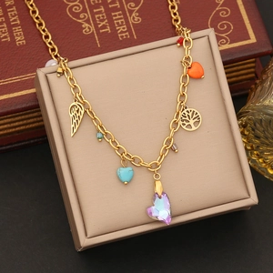 Detail of gold heart charms and crystal pendants displayed on a jewelry box background