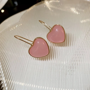 Close-up of sweet pink resin heart earrings with gold borders and delicate hooks