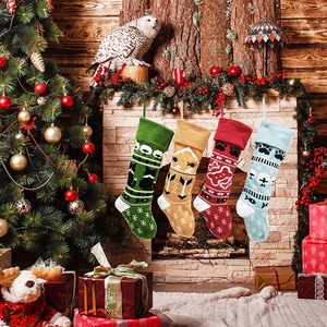 Knitted Christmas stockings with festive patterns hanging by a decorated fireplace