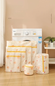 Detailed set of white mesh laundry bags with yellow bear prints and zippers for machines