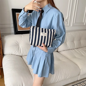 Detail of blue and white striped canvas toiletry bag with beige cloth label