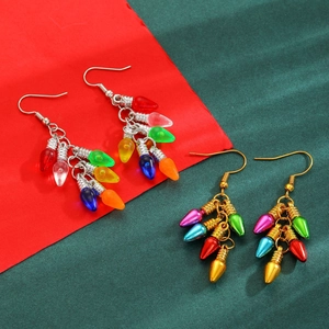 Détail de boucles d'oreilles ampoules de Noël colorées avec crochets or et argent sur fond festif