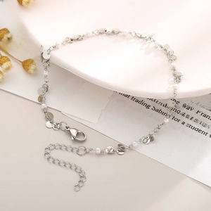 Detailed shot of silver heart anklet with white pearls and polished round sequins