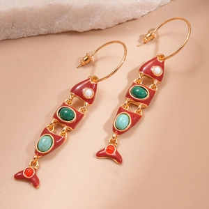 Vintage gold fish earrings with colorful enamel and tassels on pink background