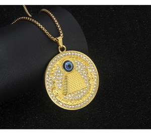 Macro shot of gold-plated pyramid evil eye necklace with crystals and Latin engraving